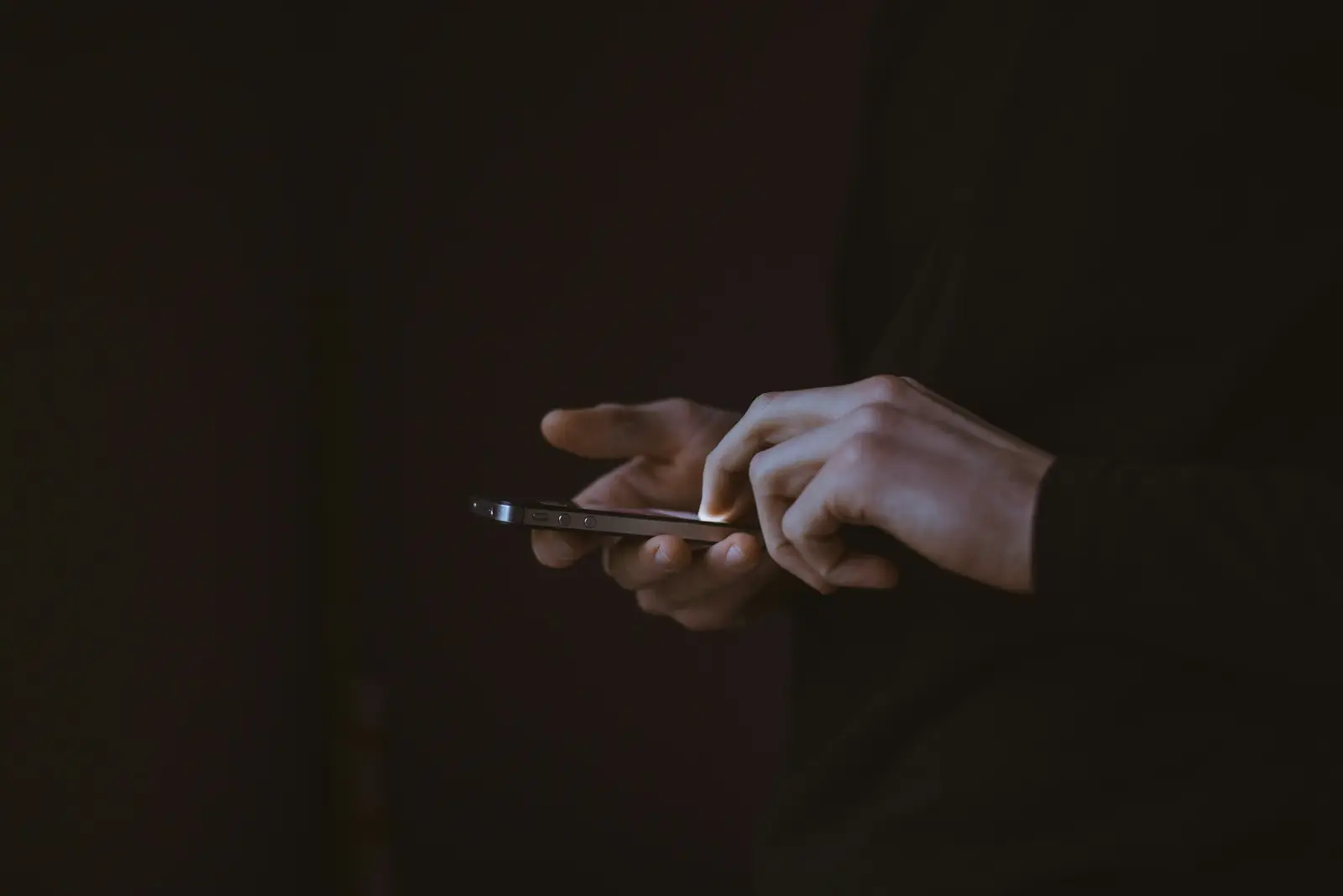 Person holding a smartphone, comparing iMessage and SMS for business messaging